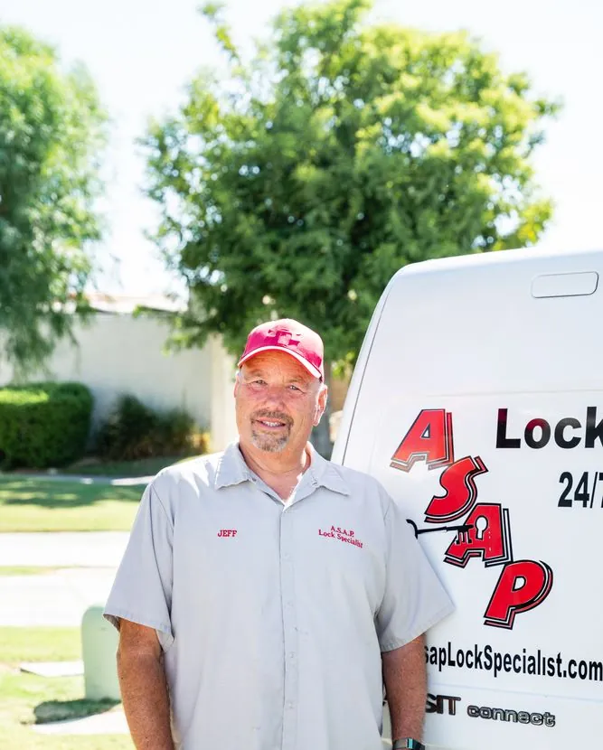 Jeff Slama standing beside the rear door of his white work van, smiling at the camera.